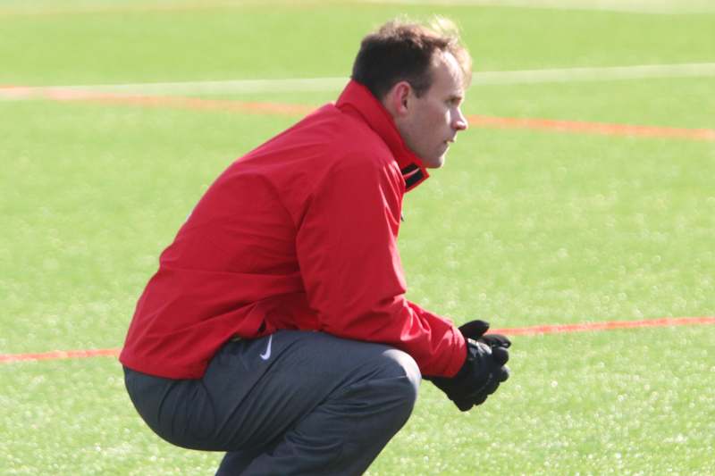 a man squatting on a field