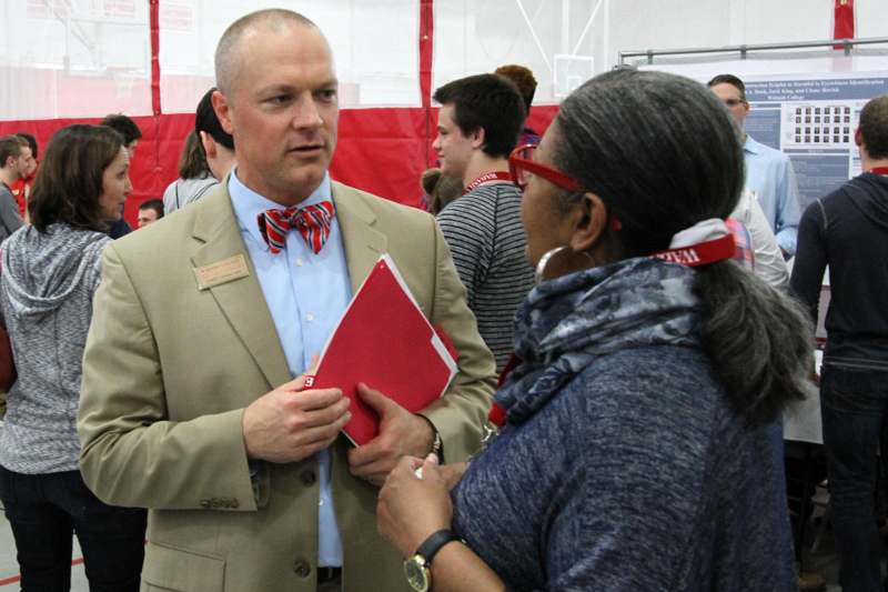 a man in a suit holding a red folder