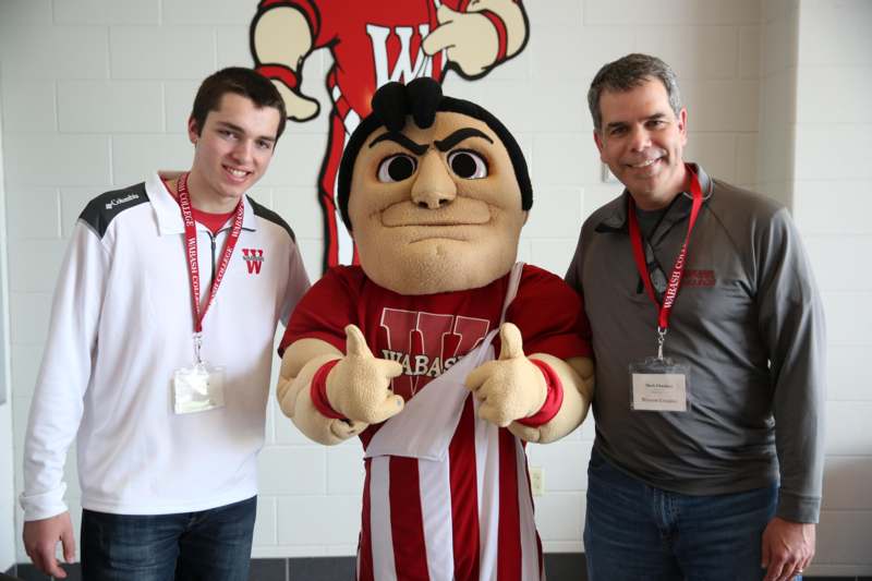 a group of men standing next to a mascot