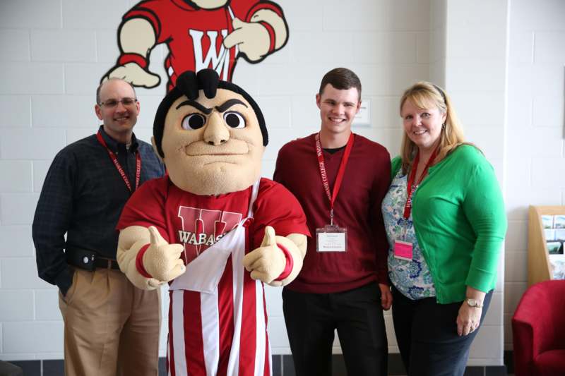 a group of people posing for a photo with a mascot