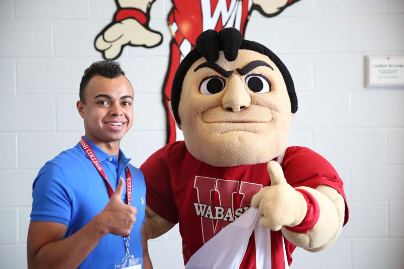 a man giving a thumbs up with a mascot