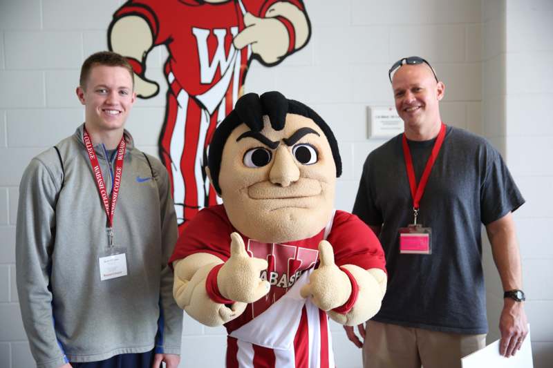 a group of men standing next to a mascot