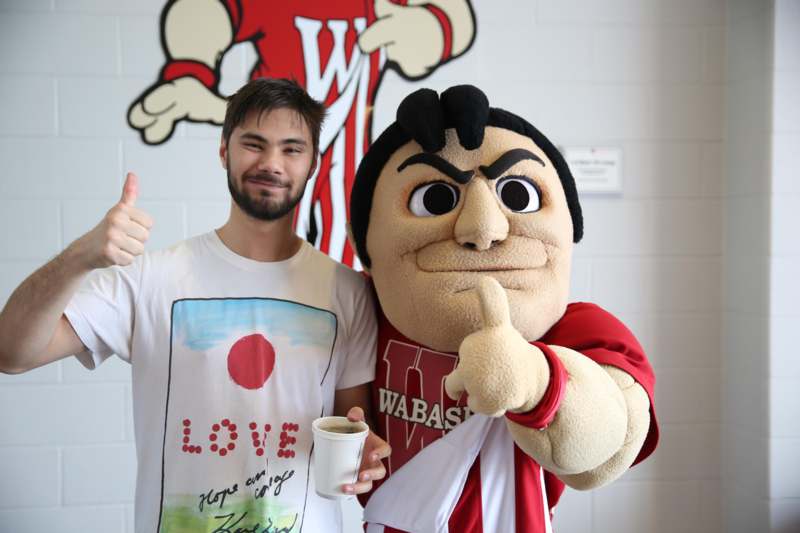 a man standing next to a mascot