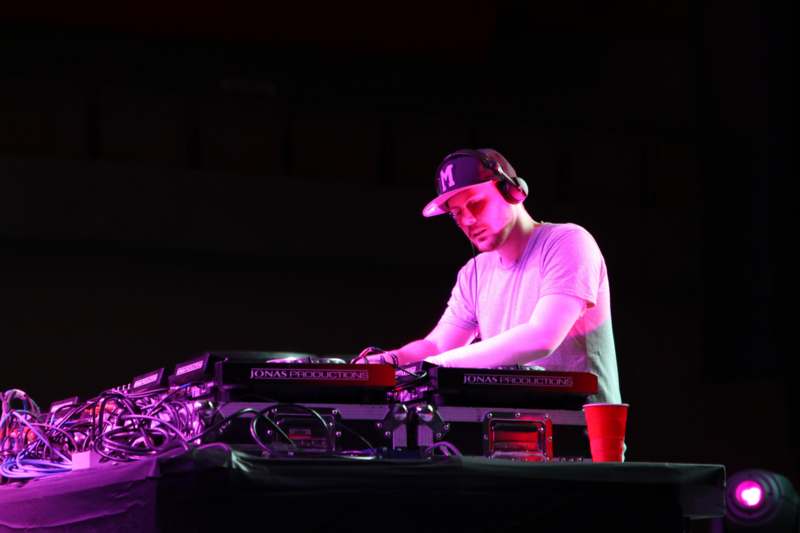 a man wearing headphones and a hat playing music