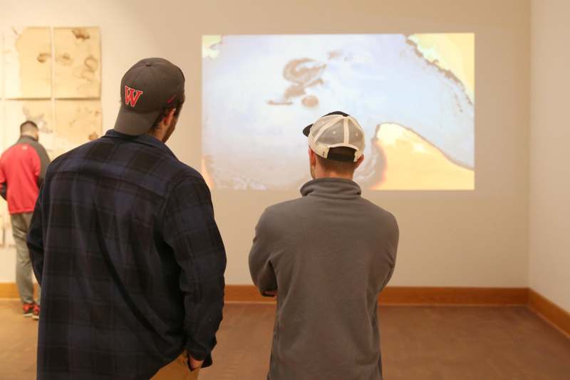 a group of men looking at a large screen