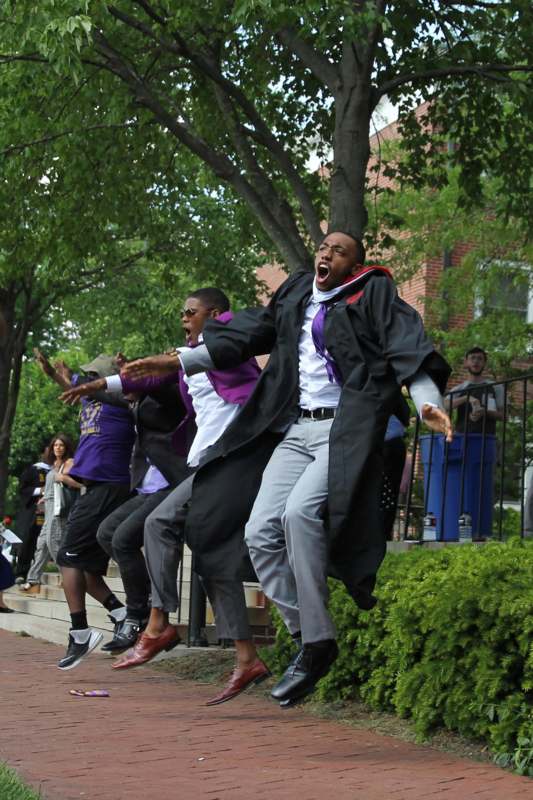 a group of people in graduation gowns jumping in the air