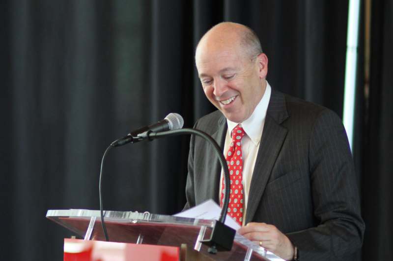 a man smiling at a podium