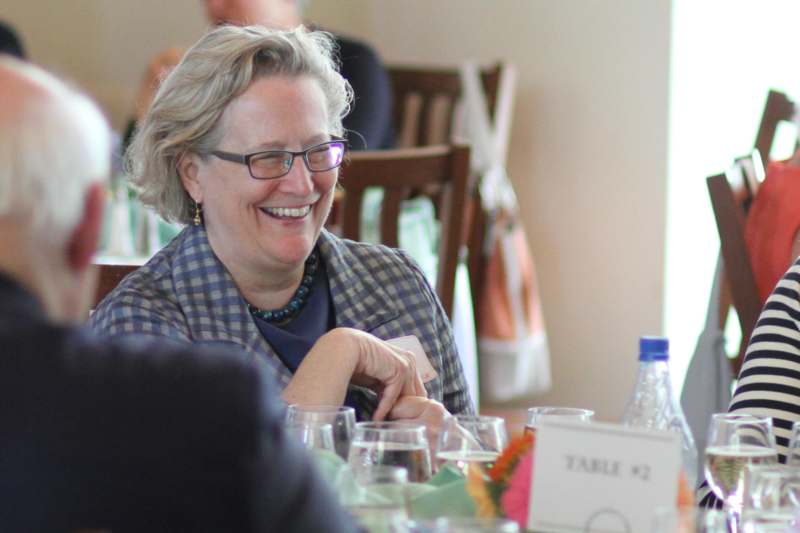 a woman smiling at a table