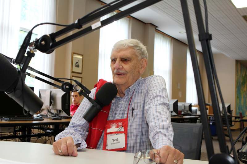 a man sitting at a desk with a microphone