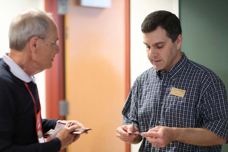 a man holding a card and looking at another man