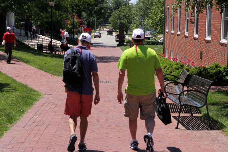 two men walking down a brick path