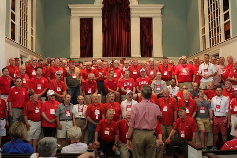a group of people in red shirts singing