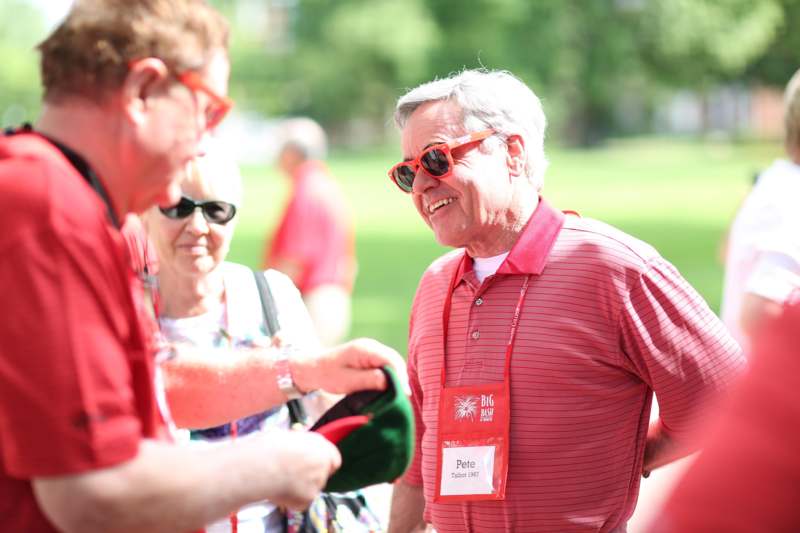 a man wearing red sunglasses and a red shirt smiling