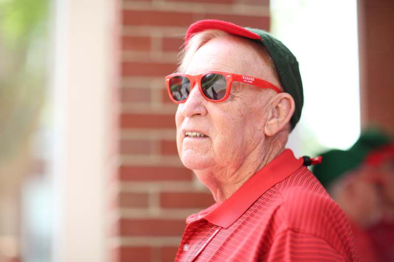 a man wearing red sunglasses and a green hat