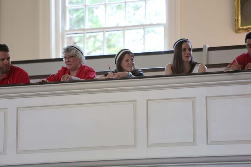 a group of women sitting on a white railing