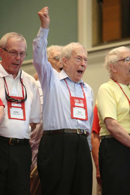 a group of older men with their arms raised