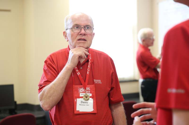 a man wearing a red shirt and a badge