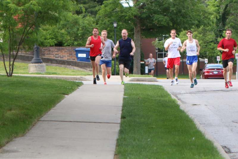a group of people running on a sidewalk