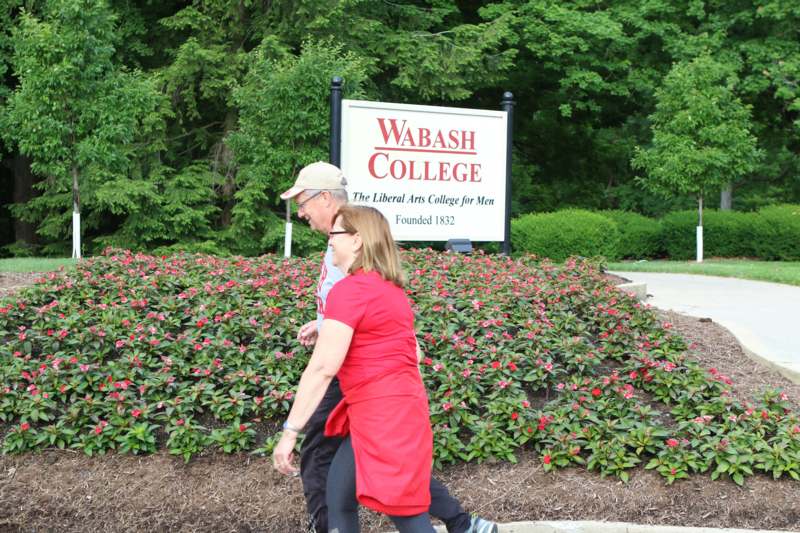 a man and woman walking in front of a sign