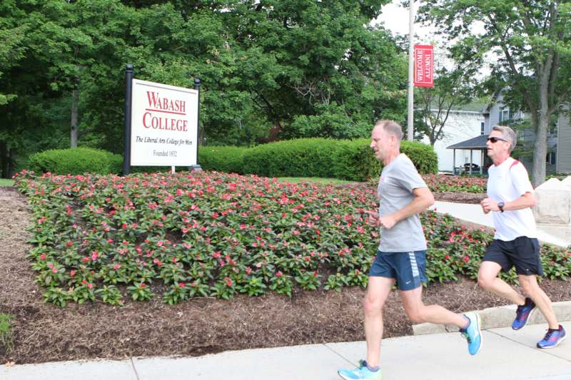 a man running on a sidewalk near a sign