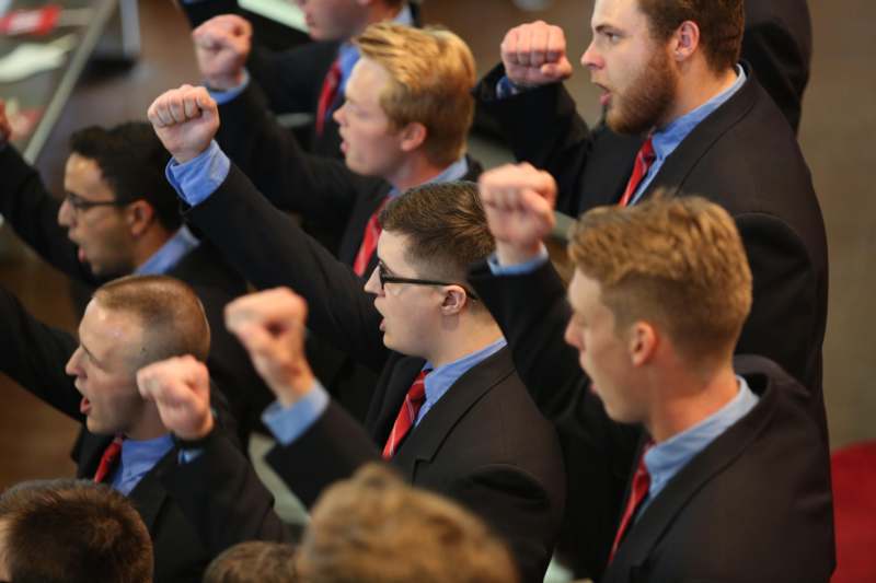 a group of men in suits raising their fists