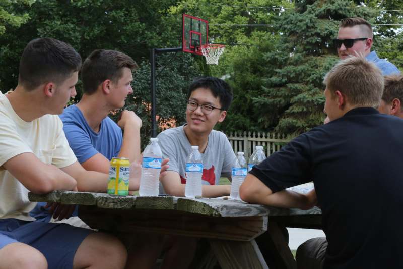 a group of young men sitting at a picnic table