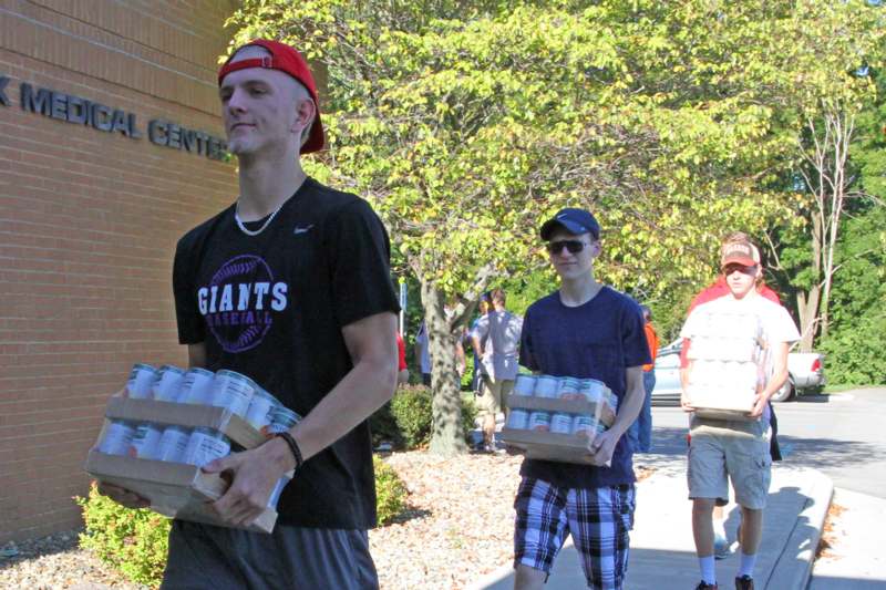 a group of people carrying cans of beer