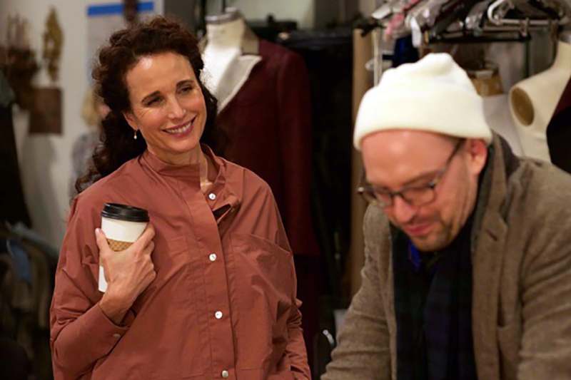 a woman holding a coffee cup and a man in a clothing store