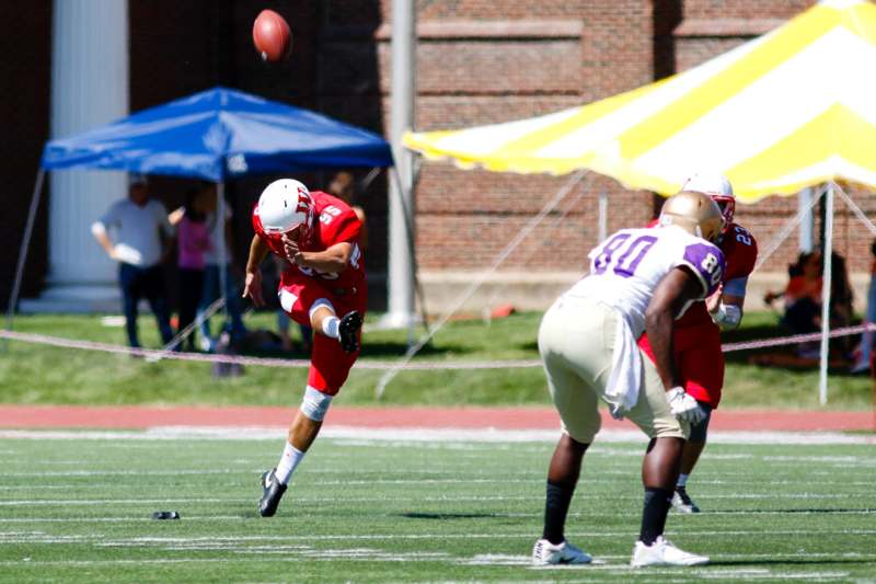 a football player in red and white uniform running with a football