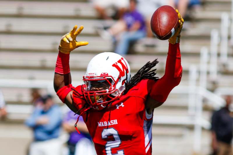 a football player in a red uniform holding a football