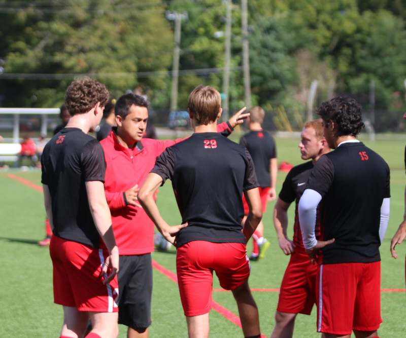 a group of men in red and black uniforms on a field