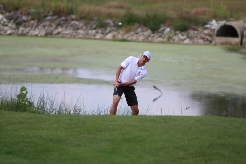 a man playing golf near water