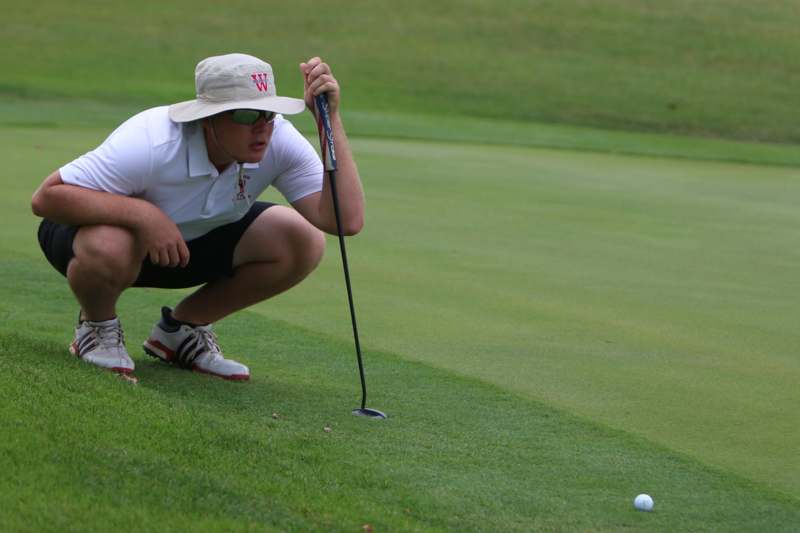 a man crouching on a golf course