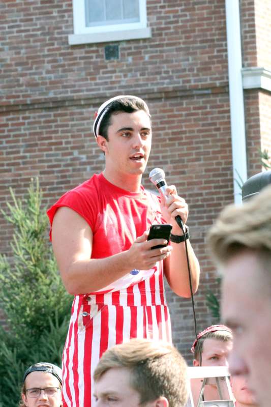 a man in a red and white striped outfit holding a microphone