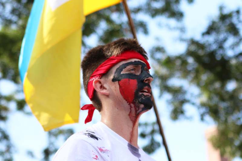 a man with face paint and a flag