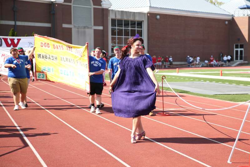 a woman in a purple dress walking on a track