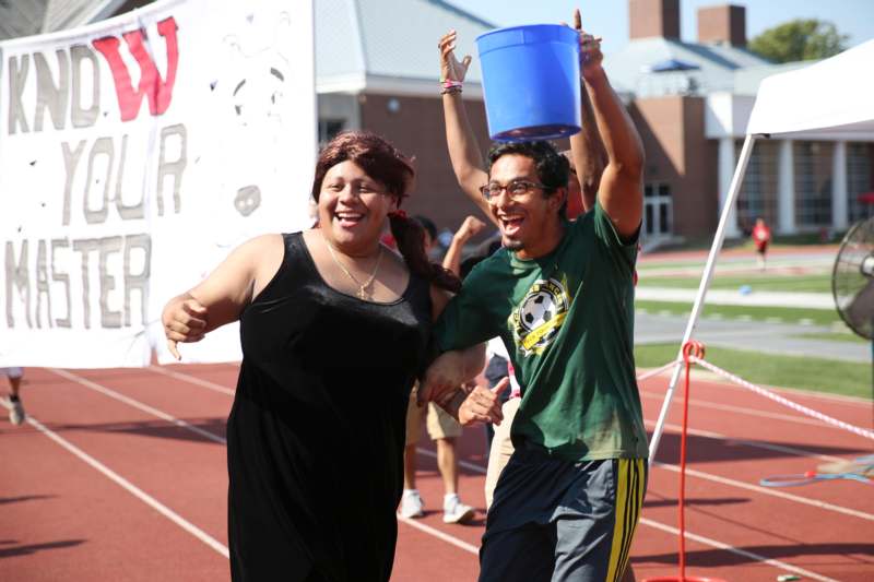 a man and woman holding a bucket on a track