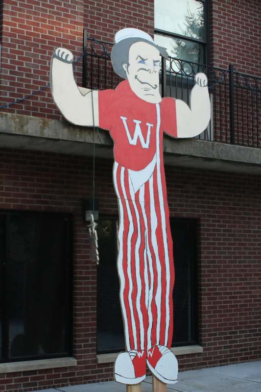 a large cardboard cutout of a man holding up his arms