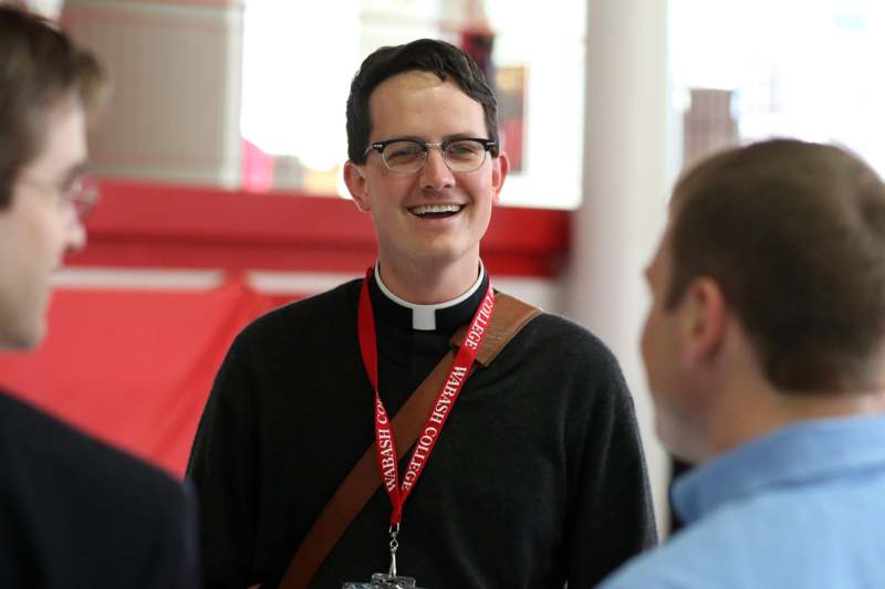 a man wearing a priest shirt and glasses