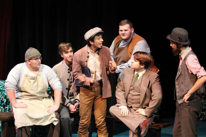 a group of men in clothing on a stage