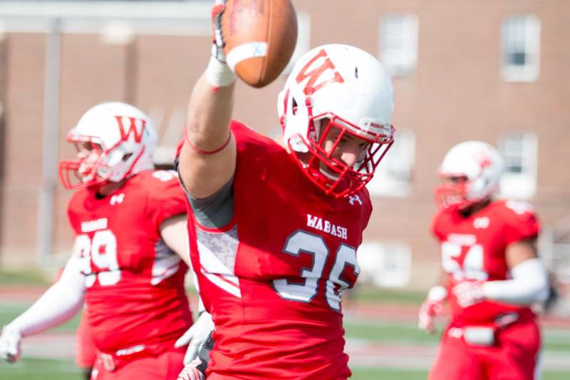 a football player in red uniform throwing a football