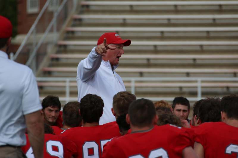 a football coach pointing at a group of people