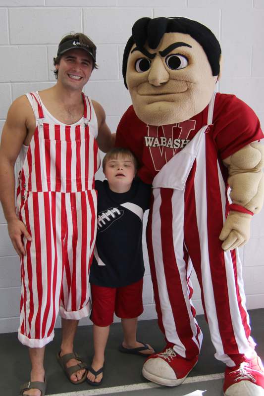 a man and child posing with a mascot