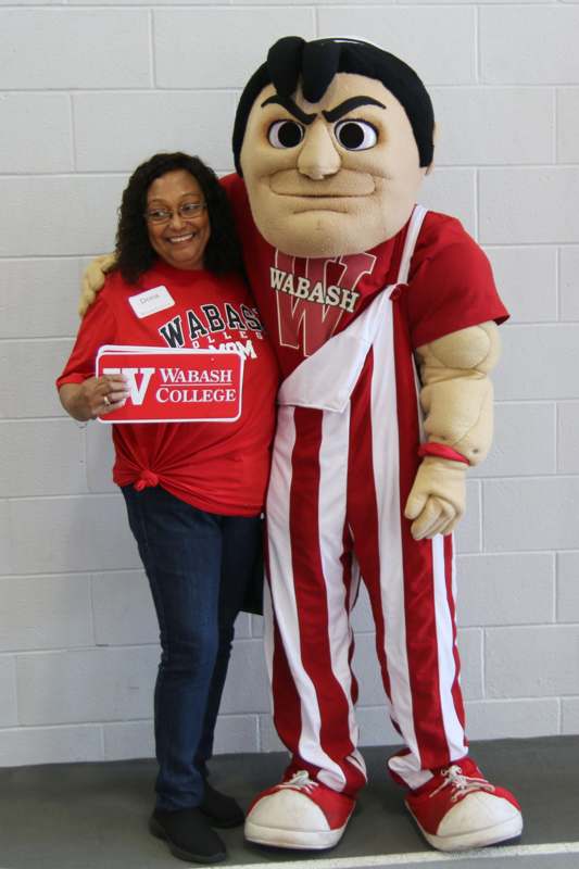 a woman standing next to a person in a mascot garment