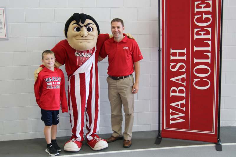 a man and boy posing with a mascot