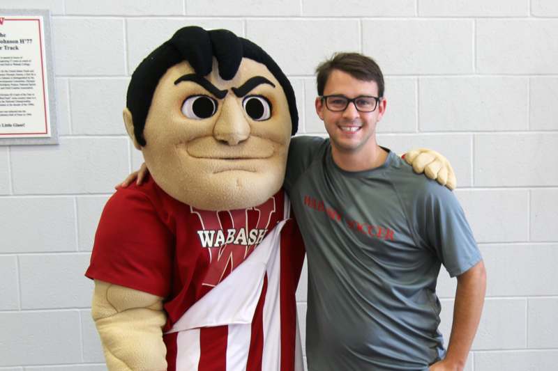 a man posing with a mascot
