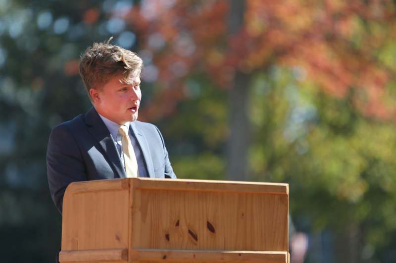a man in a suit standing at a podium