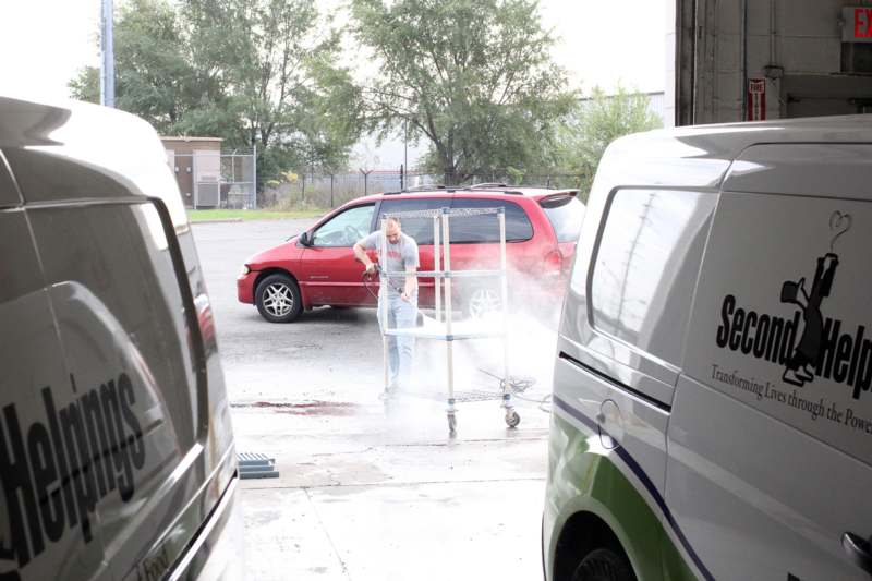 a man using a machine to clean a car