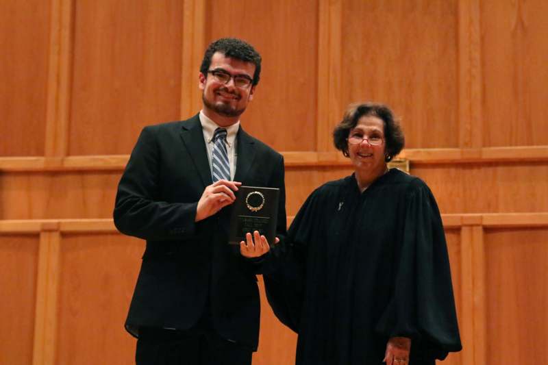 a man holding a plaque with a woman in a robe