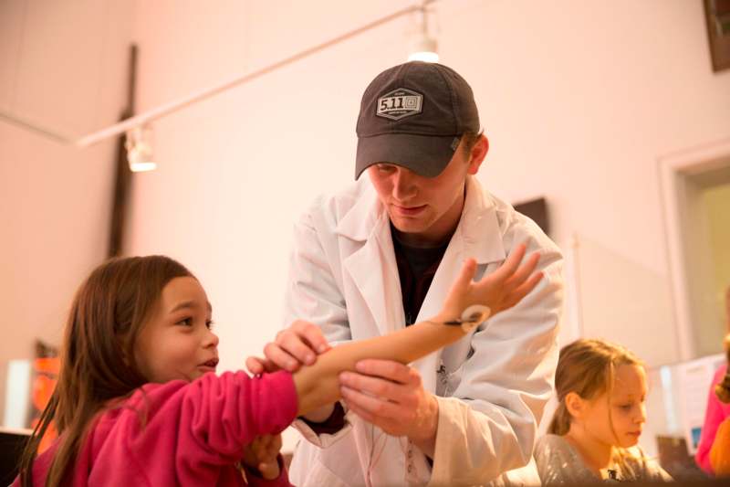 a man in a white coat examining a girl